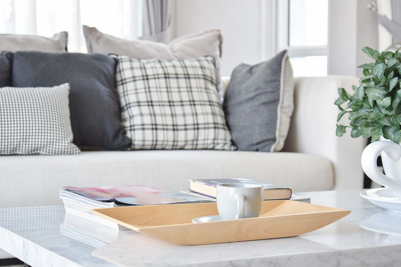 decorative wooden tray with tea cup and books in modern living room interior